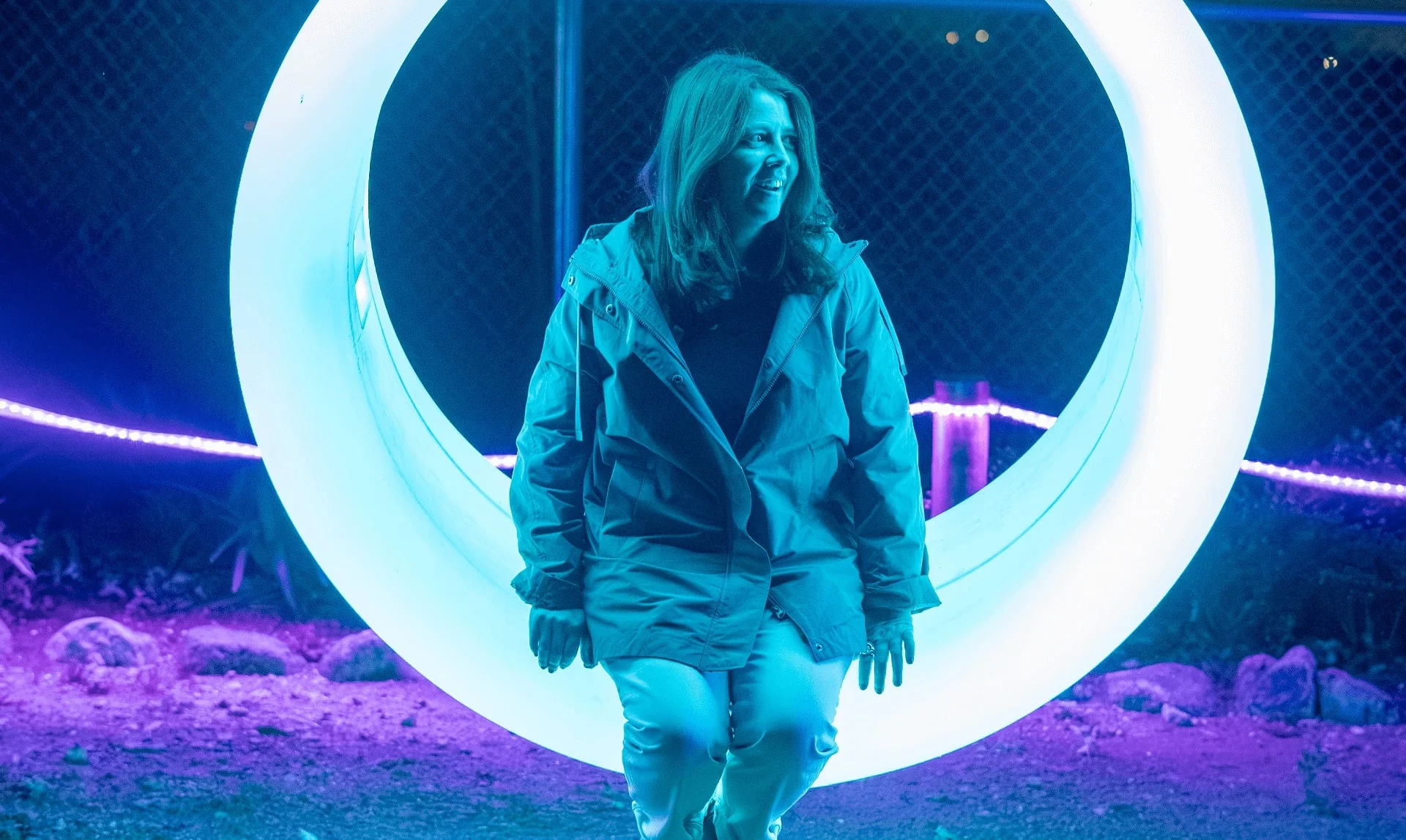 Visitante sentada en una luna creciente iluminada en Luces Salvajes