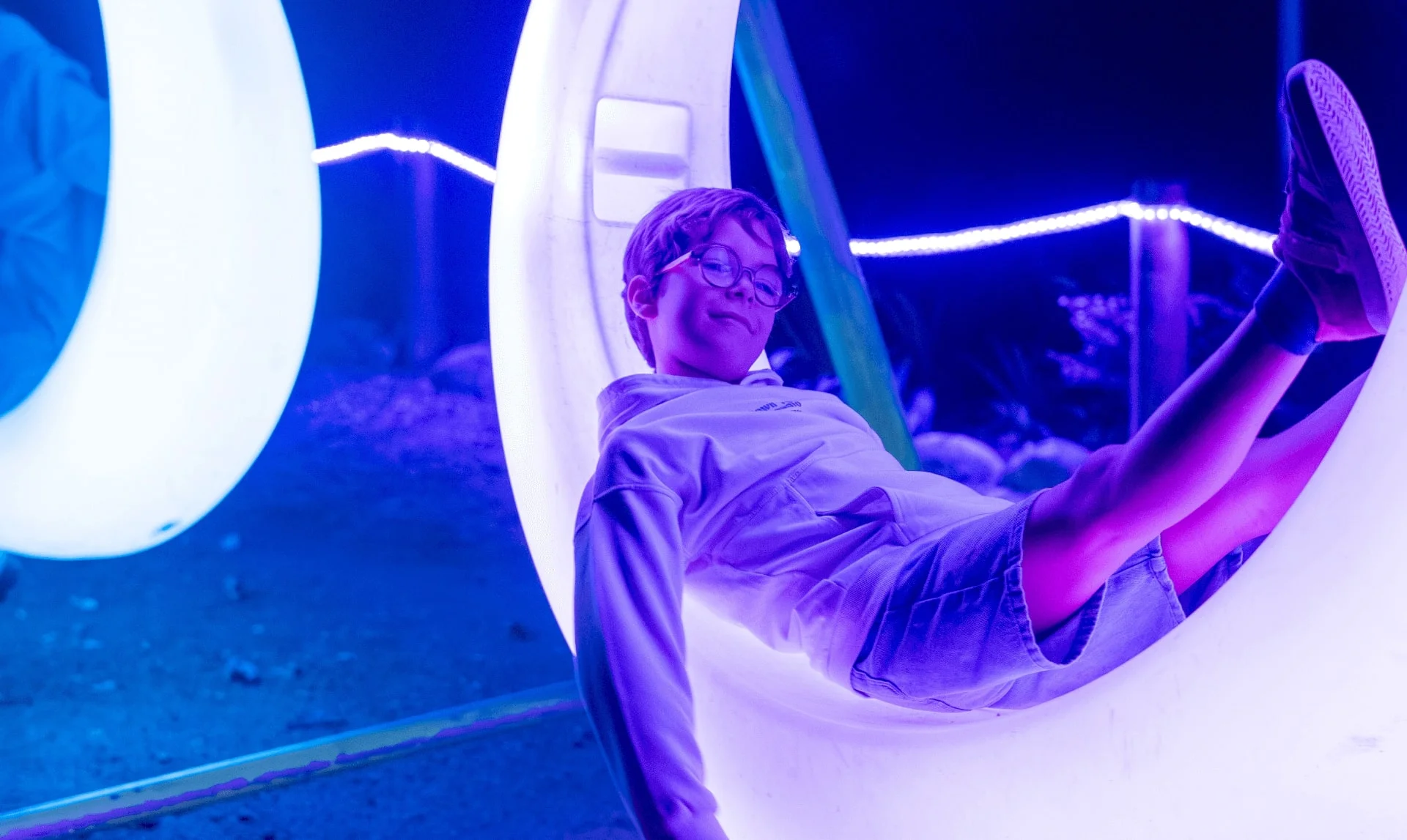 Visitante recostado en una estructura luminosa blanca en Luces Salvajes